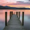 Beautiful Vibrant Pink And Purple Sunset With Wooden Jetty.
