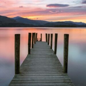 Beautiful Vibrant Pink And Purple Sunset With Wooden Jetty.