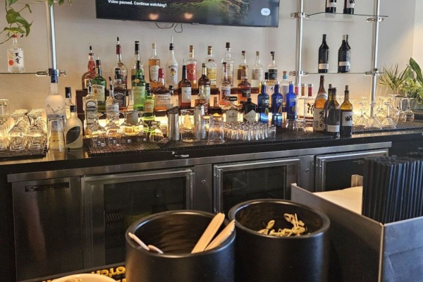 Modern commercial bar design in Sacramento showcasing illuminated shelves and seamless architectural details using polymer crown molding.