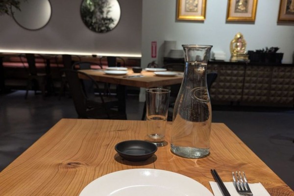 A beautifully set wooden dining table inside a chic Sacramento restaurant that utilizes decorative polymer crown molding for a finished look.