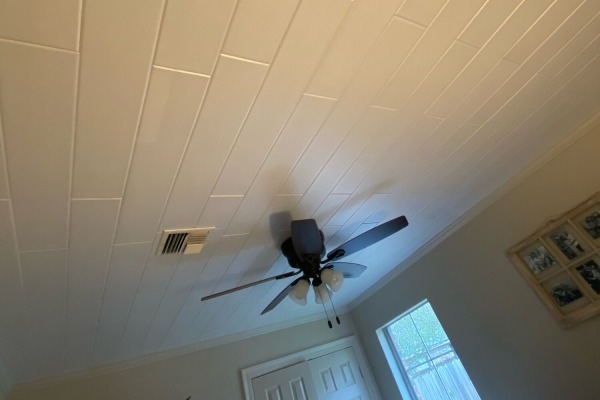 Wide angle view of a residential family room upgraded with elegant, lightweight white styrofoam ceiling planks.