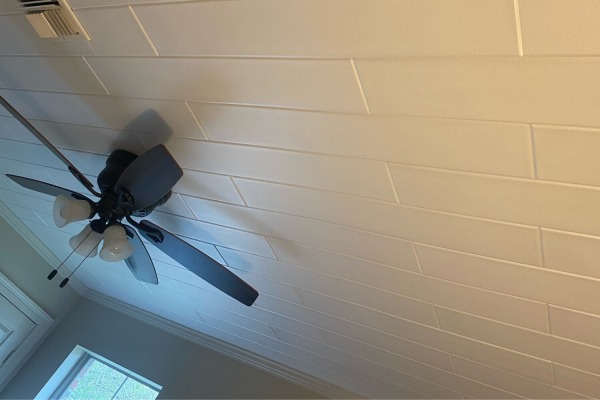 Plain white styrofoam ceiling planks installed in a Lafayette family room featuring a modern ceiling fan and air vent.