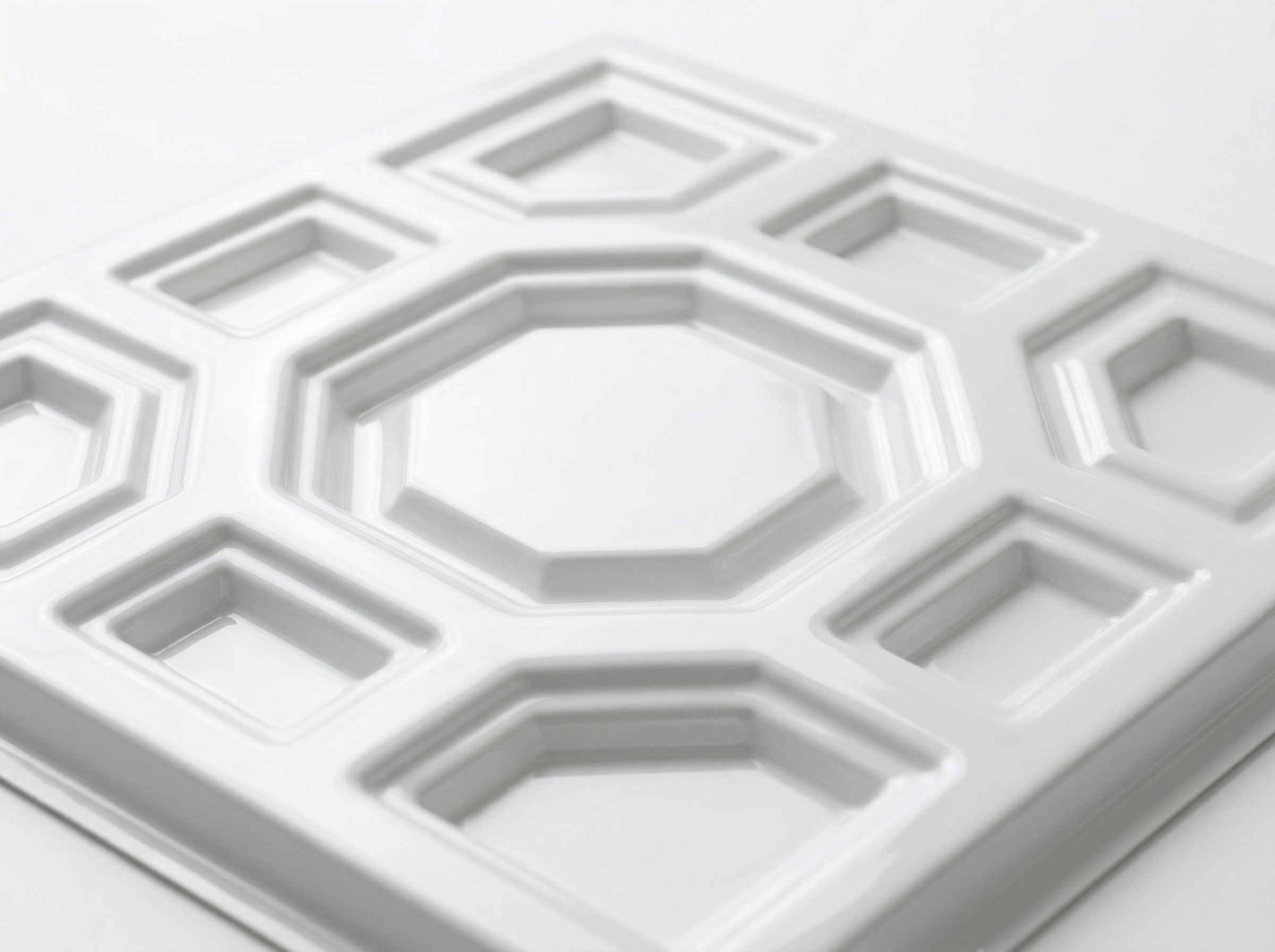 Glossy white PVC decorative ceiling tile with deep coffered pattern, macro shot
