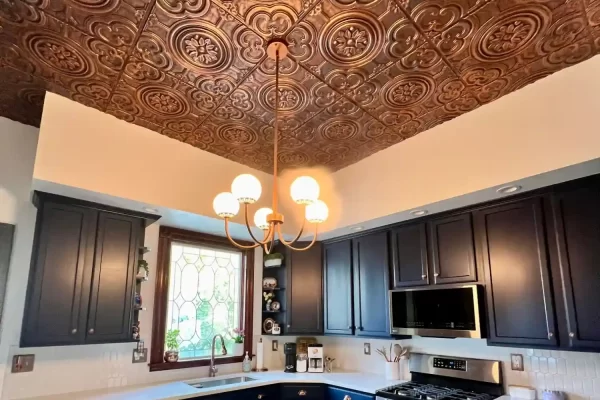 Stunning residential kitchen showcasing an elegant chandelier illuminated against a beautiful rustic copper ceiling.