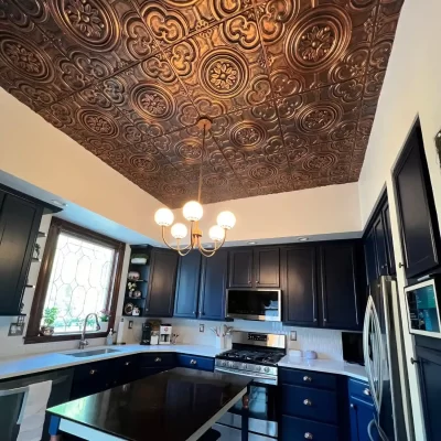 Stunning residential kitchen showcasing an elegant chandelier illuminated against a beautiful rustic copper ceiling cover