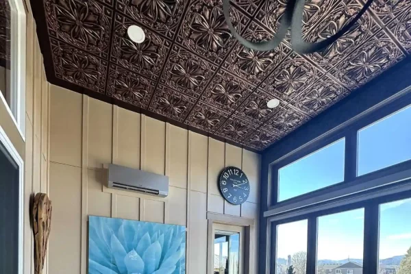 Wide interior view of a residential sunroom transformed by elegant TD10 traditional copper ceiling tiles and natural light.