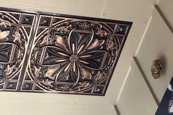 Close-up view of the TD10 Antique Floral faux tin ceiling tiles in a rich traditional copper finish.