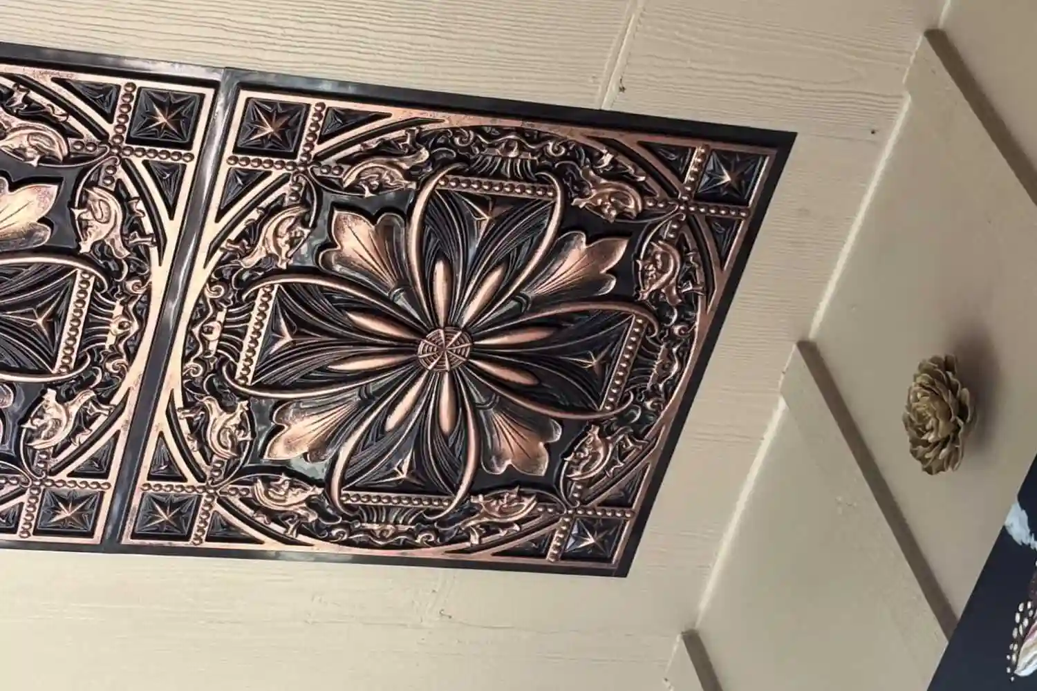 Close-up view of the TD10 Antique Floral faux tin ceiling tiles in a rich traditional copper finish.