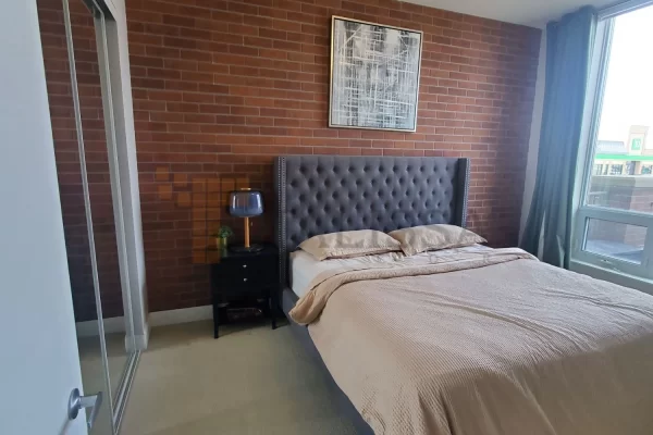 After photo of a DIY bedroom makeover in Toronto featuring lightweight industrial brown faux brick wall panels to create a cozy interior.