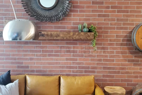 After photo of a cozy family room makeover featuring industrial style faux brick panels and warm interior lighting.