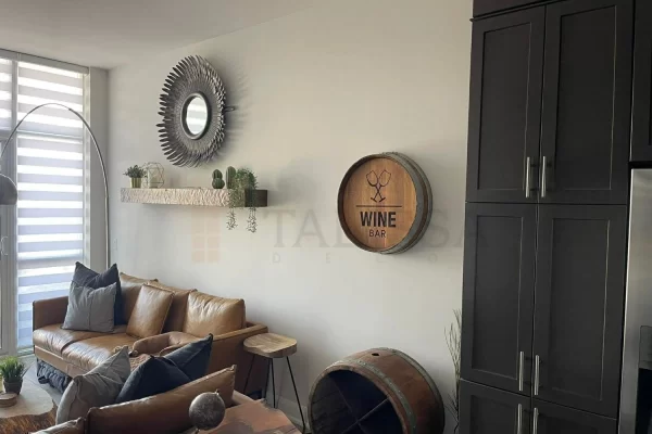 Before picture of an Oakville family room with a yellow leather couch and wine barrel sign against a plain white wall.