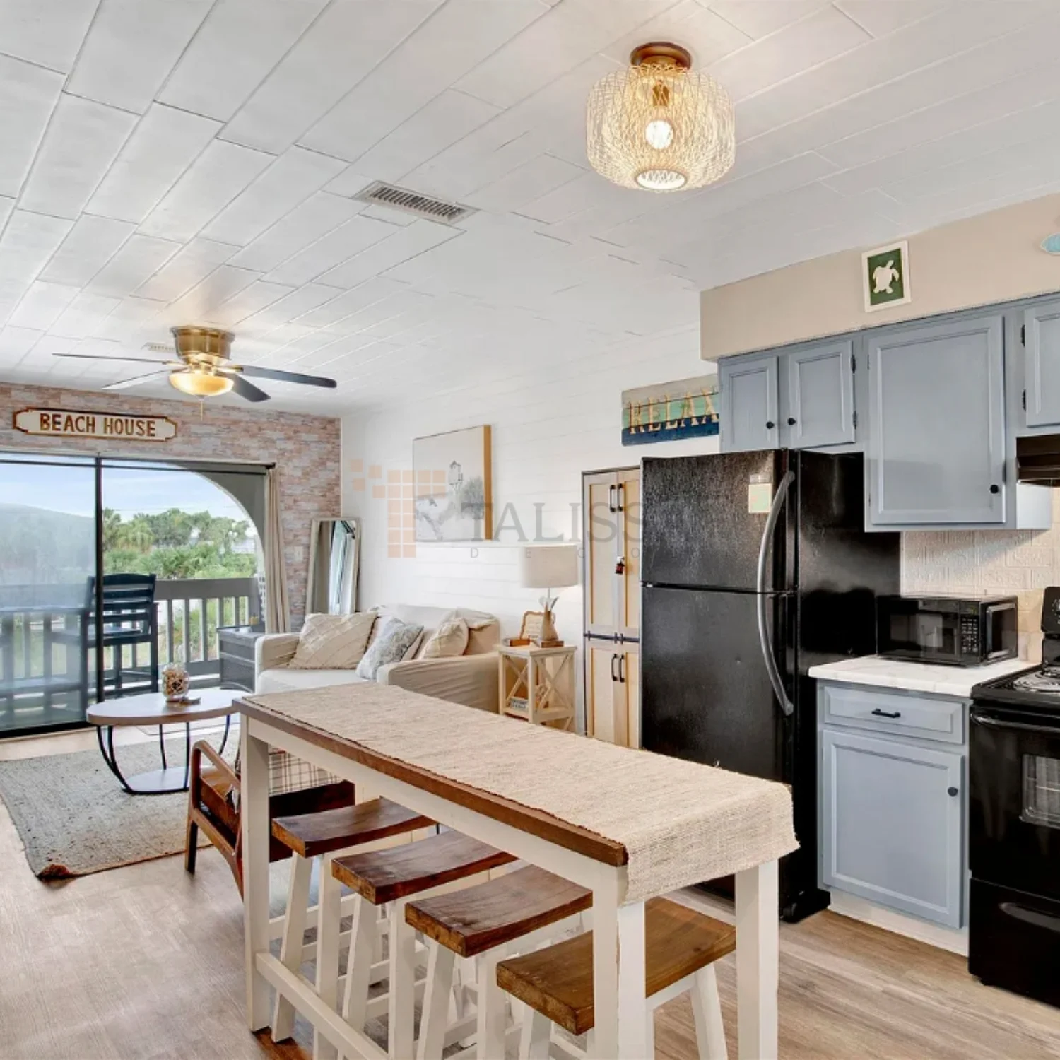 Bright coastal beach house kitchen featuring crisp white styrofoam ceiling planks that beautifully complement the light blue cabinetry.