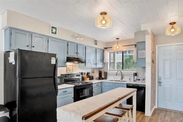 Side view of a beautiful coastal kitchen with a fresh white plank ceiling, showcasing a seamless, no-demolition upgrade.