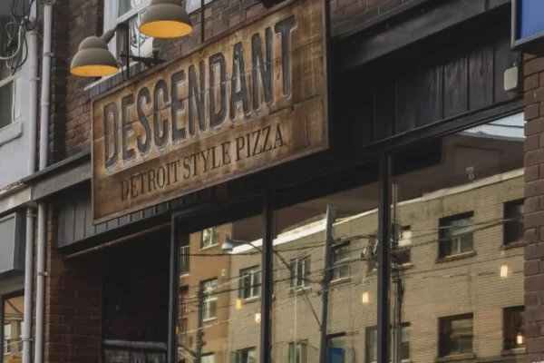 Beautiful dining room at a Toronto pizzeria, showcasing eclectic art perfectly matched with TD11 Victorian Tin Ceiling Tiles in a smoked copper finish.