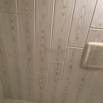 Close-up view of Driftwood Ash Wood Look Styrofoam Ceiling Planks seamlessly installed around a bathroom exhaust vent, showcasing the realistic wood grain texture.