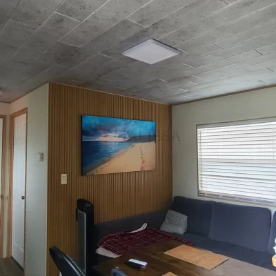 Completed mobile home living room renovation featuring modern concrete look foam ceiling planks in Muskoka, ON.