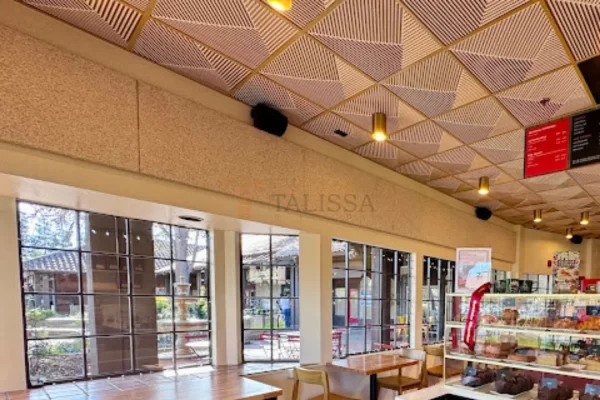 Warm lighting reflecting beautifully off decorative PVC ceiling tiles in a vibrant coffee shop setting.