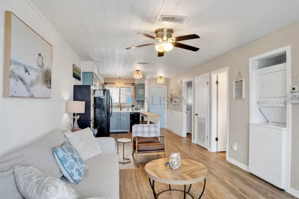 Open concept living room and kitchen in a coastal beach house, brightened up by the continuous installation of white styrofoam ceiling planks.