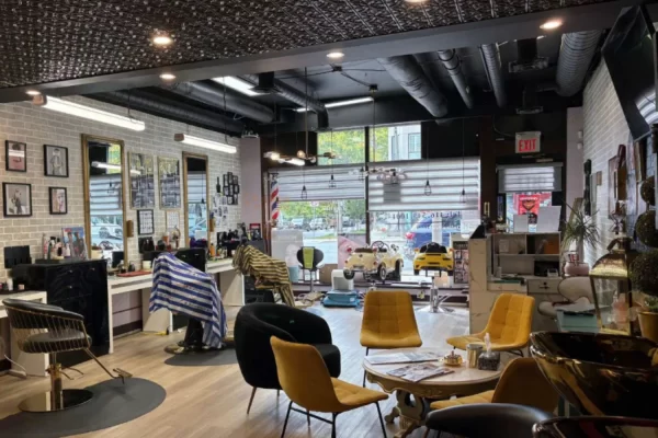 Wide view of a stylish salon interior highlighting the 150 Classic Pattern Tin Ceiling Tiles in Antique Copper above the cutting area.