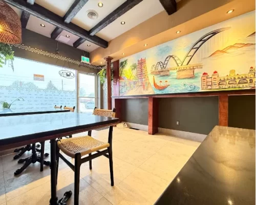 Dining area at Aaha Restaurant in Scarborough featuring rustic dark walnut faux wood beams on the ceiling.