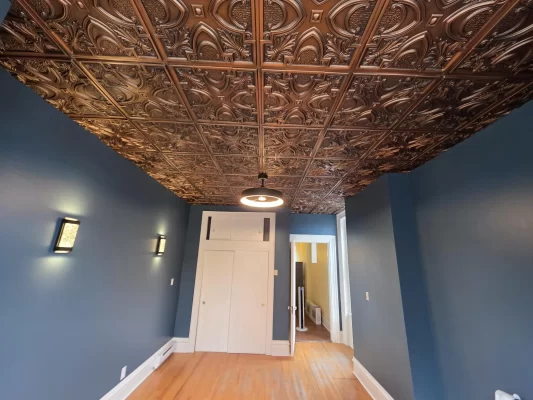 Completed office ceiling renovation in New Brunswick showcasing a stunning Victorian-style faux tin design.