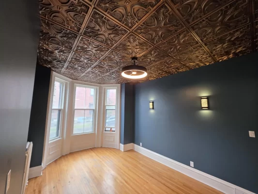 Bright office space with a large window, perfectly complementing the warmth of the new aged copper faux tin ceiling.