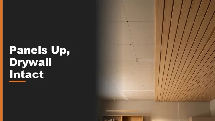 A ceiling split between exposed drywall and finished thin wood panels