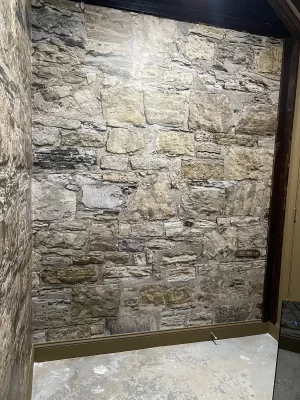 Full wall covered in the MU1458 Castle Stones mural, showing aged grey and tan stone courses