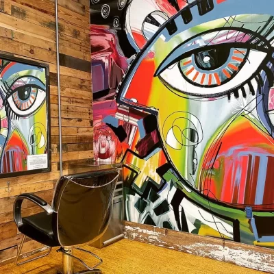Close-up of the Picasso mural eye next to a reclaimed wood wall and framed salon mirror