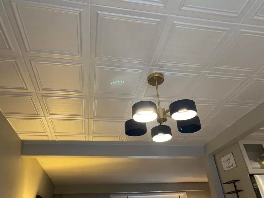 White RM24 Styrofoam ceiling tiles above a black and brass chandelier in a Waterloo, ON dining area